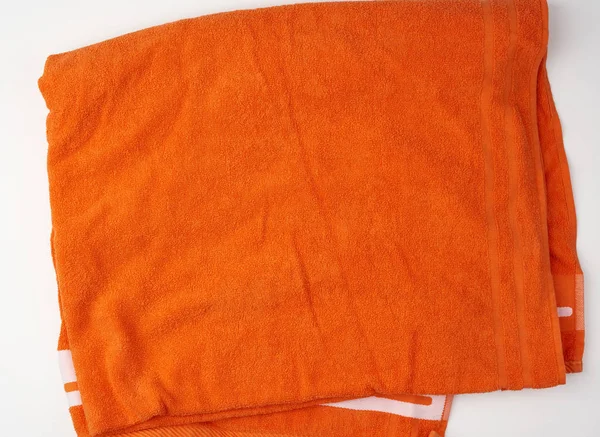 Складений ванна террі апельсиновий рушник на білому фоні — стокове фото
