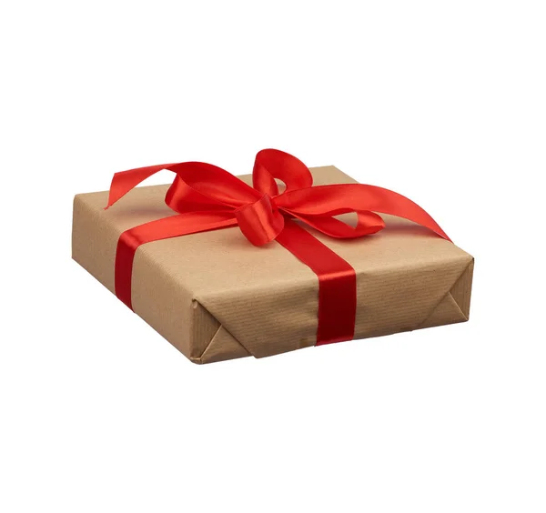 Vierkante doos verpakt in bruin kraftpapier en gebonden met een zijden rood — Stockfoto