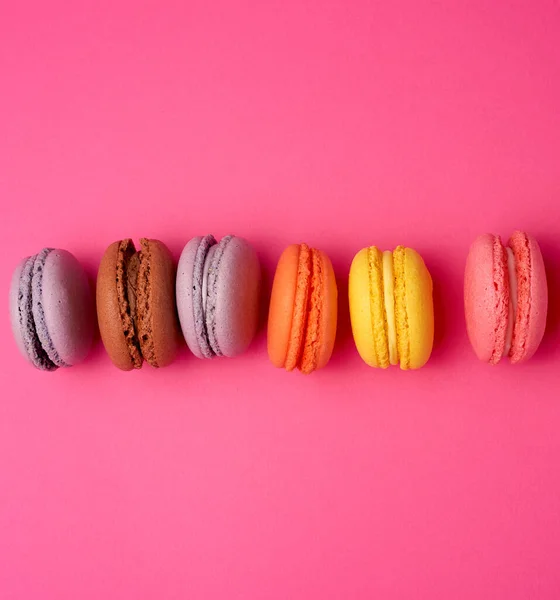Kleurrijke gebakken Macarons amandelmeel op een roze achtergrond — Stockfoto