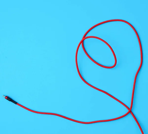 Микрокабель для зарядки мобильных устройств в красную текстильную косу — стоковое фото