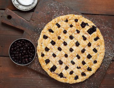 Ahşap zemin üzerinde pişmiş siyah üzümlü turta.