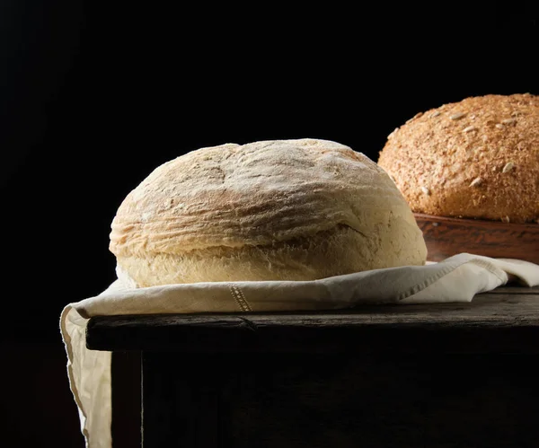 Two loaves of baked round bread lay on a white napkin — Stock Photo, Image