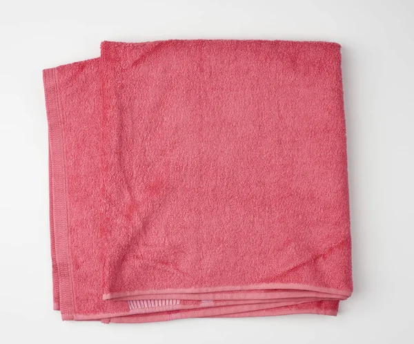 Gevouwen badstof roze handdoek op een witte achtergrond — Stockfoto