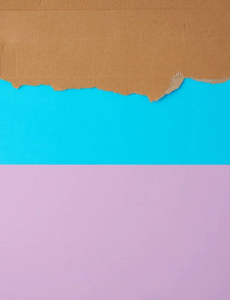 Roztržené okraje vlnitého lepenkového papíru na modrém purpurovém hřbetě — Stock fotografie