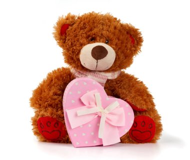 Kahverengi kıvırcık ayıcık oturur ve pembe bir karton kutu tutar. 