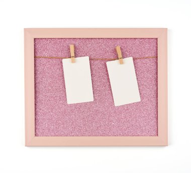 pembe parlak çerçeve, ipler ve boş beyaz çarşaflar asılı.