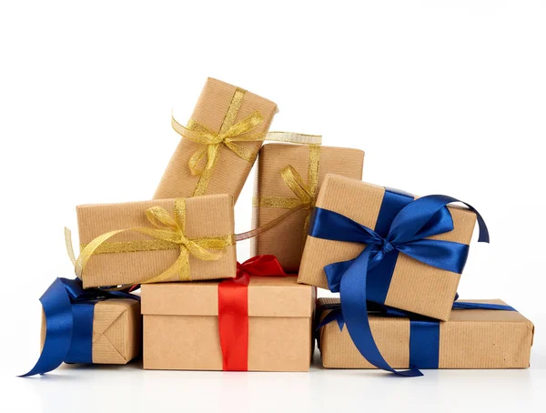 Stapel von Geschenken in braunes Kraftpapier gewickelt und mit Seide gebunden — Stockfoto