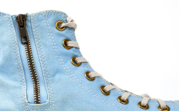 Fragment of a blue sneaker with white textile laces and an iron — Stock Photo, Image