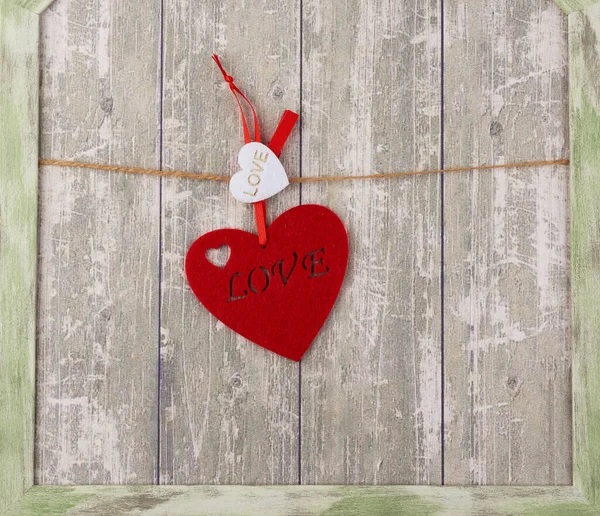 Red felt heart hanging on a brown rope — Stock Photo, Image