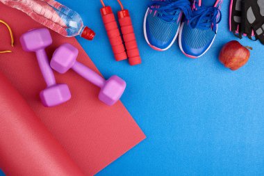 Bağcıklı mavi spor ayakkabılar, bir şişe su.