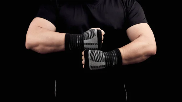Adult man in a black uniform and muscular body is standing in a — Stock Photo, Image