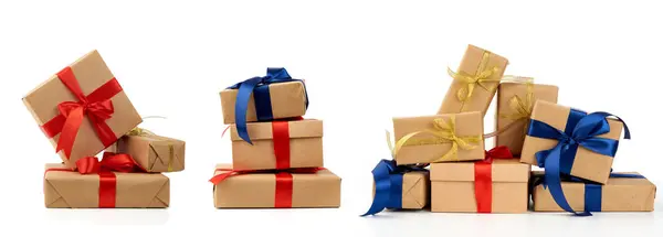 Stack of gifts wrapped in brown kraft paper and tied with silk b — 스톡 사진