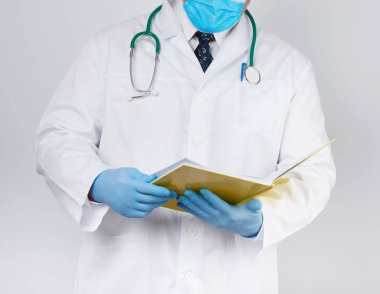 doctor in a white coat, blue latex sterile gloves holds an open 
