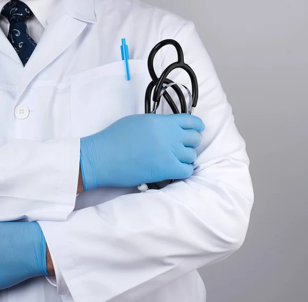 Adulto médico masculino em um casaco médico branco fica e detém uma bla — Fotografia de Stock