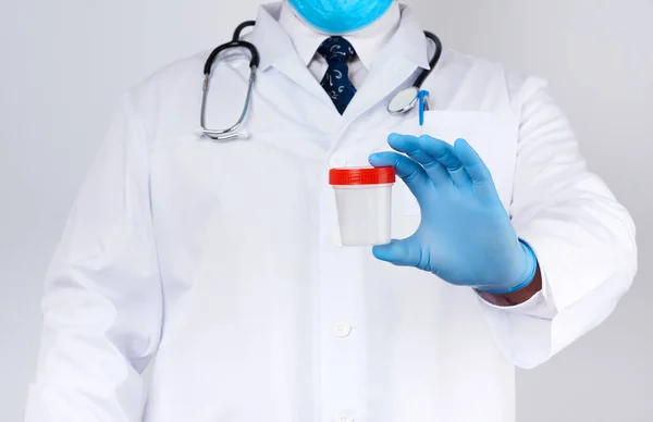 Mężczyzna lekarz w biały płaszcz i krawat stoi i trzyma plastik c — Zdjęcie stockowe
