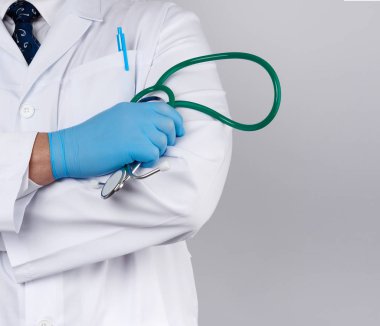 Beyaz önlüklü yetişkin erkek doktor bir dev tutuyor.