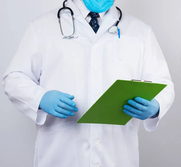 Doctor masculino con una bata blanca, guantes de látex azul, estetoscopio colgado — Foto de Stock