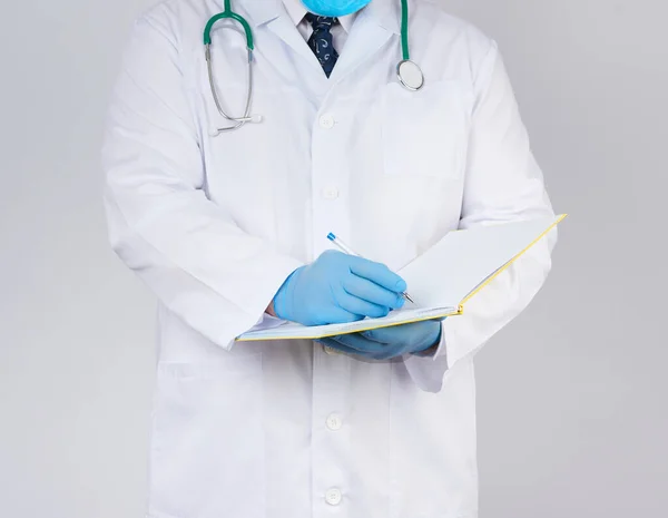 Lekarz Białym Płaszczu Niebieskie Lateksowe Rękawiczki Sterylne Trzyma Otwarty Żółty — Zdjęcie stockowe