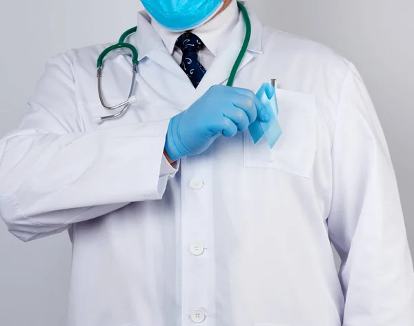 Lekarz Białym Płaszczu Krawacie Stoi Trzyma Niebieską Wstążkę Jedwabną Pętli — Zdjęcie stockowe