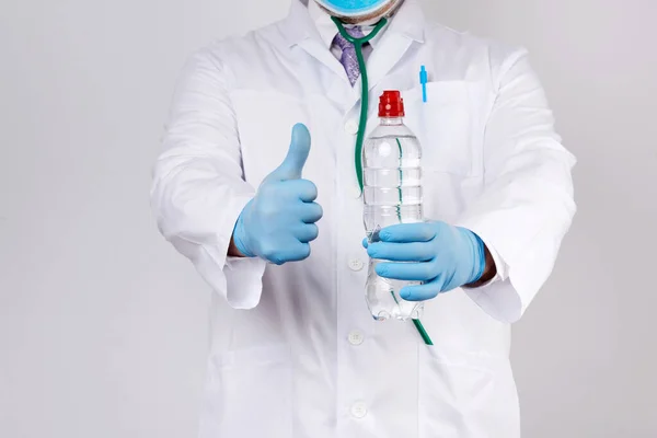Lekarz Białym Płaszczu Niebieskie Rękawice Lateksowe Posiada Przezroczystą Butelkę Wody — Zdjęcie stockowe