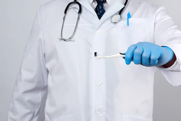 치료사는 가운을 파란색 장갑은 칫솔을 있습니다 솔질하는 — 스톡 사진