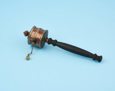 Mavi arka planda bakır Tibet dua davulu, üst görünüm