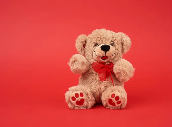 Niedlicher Kleiner Brauner Teddybär Spielzeug Sitzt Auf Rotem Hintergrund Nahaufnahme — Stockfoto