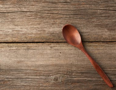 Eski tahtalardan gri tahta bir yüzey üzerinde boş kahverengi ahşap kaşık.