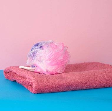 Pembe katlanmış havlular ve mavi arka planda plastik bir bez yığını.