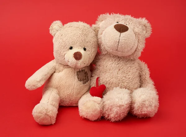 Two Teddy Beige Bears Sitting Huddled Together Toys Red Background — Stock Photo, Image