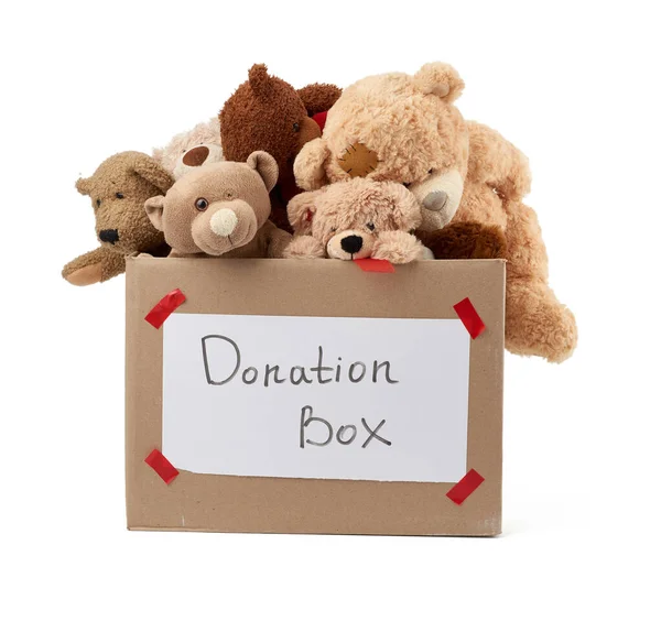 brown cardboard box filled with soft toys,inscription on the box, concept of charity and assistance to needy children