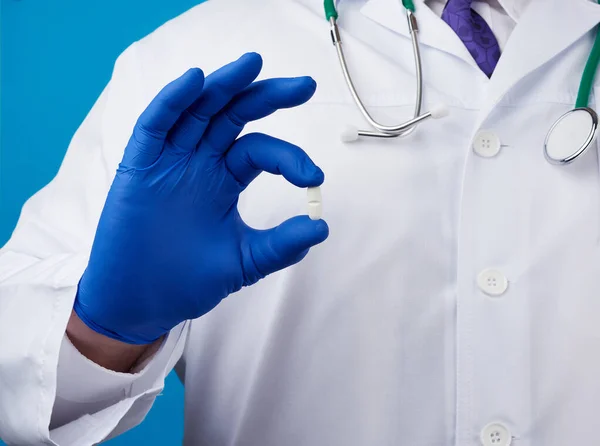 Mano Masculina Guantes Estériles Azules Sostiene Una Píldora Blanca Ovalada —  Fotos de Stock