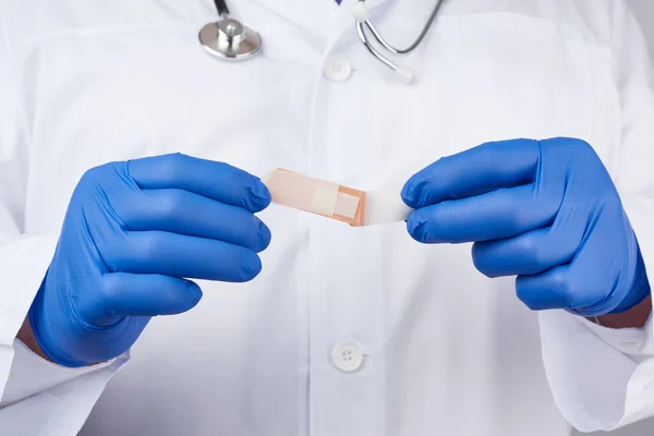 Doctor Masculino Una Capa Blanca Guantes Médicos Látex Azul Sostiene —  Fotos de Stock