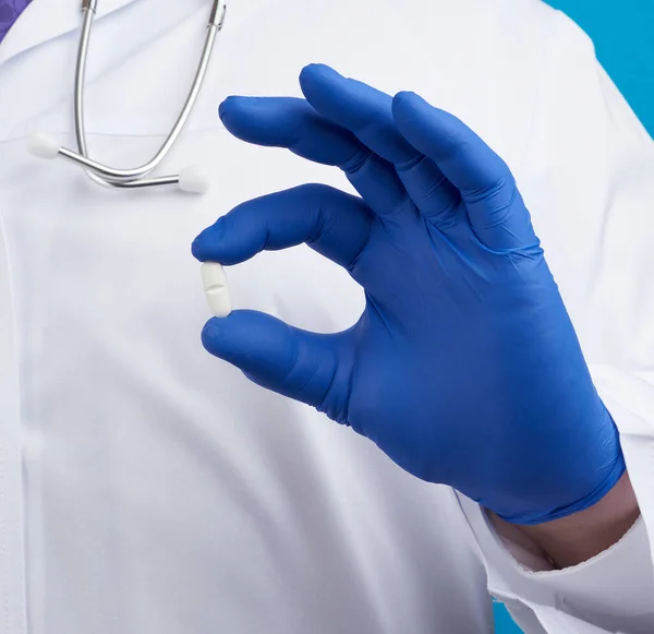 Mano Masculina Guantes Estériles Azules Sostiene Una Píldora Blanca Ovalada —  Fotos de Stock