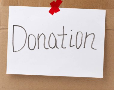 Beyaz bir çarşafa yazıt bağışı ve yapıştırılmış kahverengi karton kağıt. Gönüllü olma ve terfi etme kavramı.