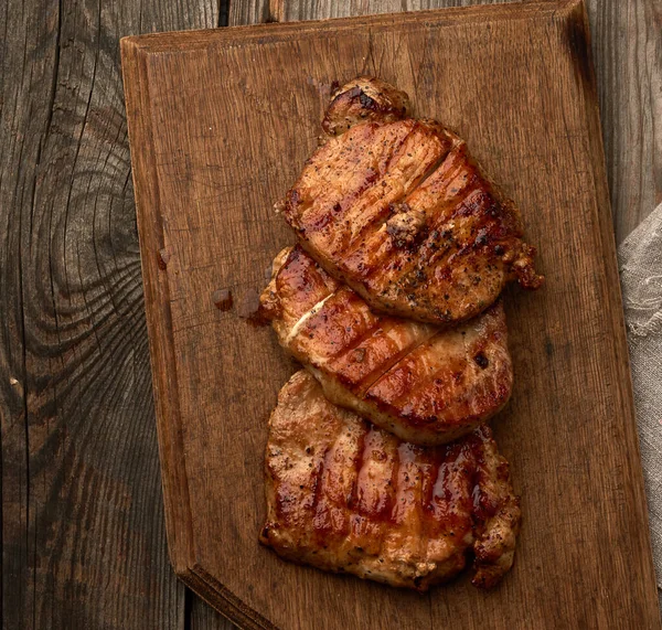 Smažený Šťavnatý Vepřový Steak Dřevěné Desce Grilované Maso Výhled Shora — Stock fotografie