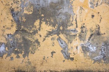 Puslu parçalarla çatlamış sarı beton duvar, tam çerçeve, tasarımcının eski dokusu.