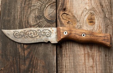 Eski tahtalardan ahşap bir masanın üzerinde eski mutfak bıçağı, üst manzara, kapat.