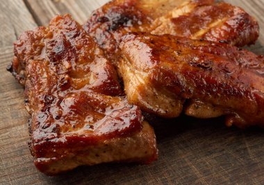 Kahverengi ahşap bir tahtada kızarmış domuz kaburgası, yakın çekim.