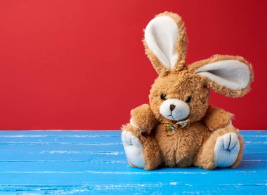 Kırmızı arkaplanda sevimli bir tavşan oyuncağı, şenlikli bir zemin, kopyalama alanı