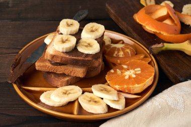 Çikolatalı sandviç ve muz dilimleri tabakta, sabah kahvaltısı, kapat.