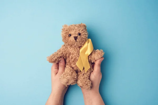 Ženské Ruce Drží Malého Medvídka Žlutou Stuhou Složenou Smyčce Modrém — Stock fotografie