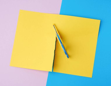 Çocuk makası. Sarı bir sayfa kes, üst görüş.