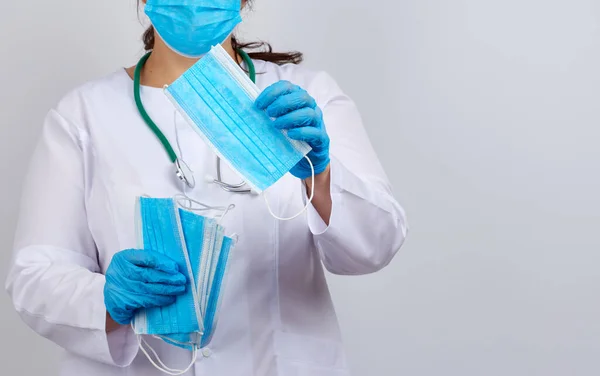 Arzt Weißem Mantel Und Maske Hält Einen Stapel Schützender Gesichtsmasken — Stockfoto