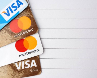 Kherson, Ukrayna - 22 Nisan 2020: Plastik kartlarda Visa ve Mastercard logoları, siyah çizgili beyaz kağıt arka plan, liste ve yazıtlar için yer, dünyanın iki büyük finans şirketi, üst görünüm