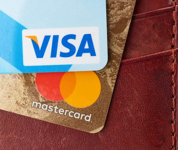 Kherson, Ukrayna - 22 Nisan 2020: Plastik kartlarda Visa ve Mastercard logoları, kahverengi arka plan, dünyanın iki büyük finans şirketi