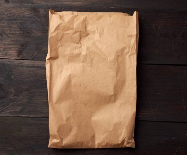 Kahverengi ahşap arka planda yiyecek ambalajı için açık kahverengi kese kağıdı, çevreyi kurtarmak için plastik torbaların reddedilmesi kavramı