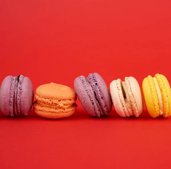 Geel Paars Groen Rond Gebakken Macarons Taarten Een Rode Achtergrond — Stockfoto