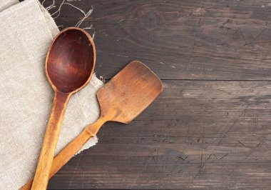 Tahtalardan, üst manzaradan, kopyalama alanından kahverengi ahşap arka planda boş tahta kaşık ve spatula