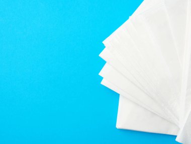 Mavi arka planda beyaz kağıt peçete yığını, yazı için yer
